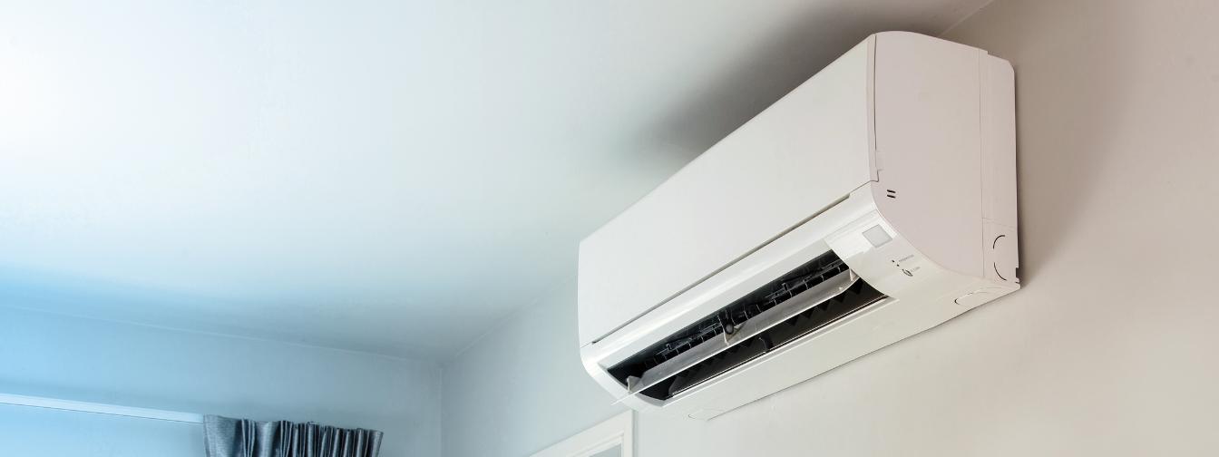 Wall-mounted white air conditioning unit in a modern room, showcasing energy-efficient cooling technology for home climate control. Perfect for discussions on HVAC installation, air conditioning maintenance, and indoor comfort solutions.