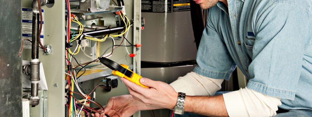 A professional HVAC technician uses a multimeter to test electrical connections in a furnace, showcasing the importance of thorough inspections and diagnostics for ensuring safe and efficient heating system operation.