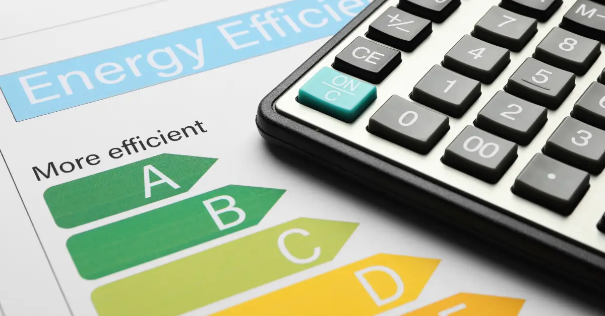 A close-up of an energy efficiency rating chart, showing color-coded labels from green “A” (more efficient) to yellow “D,” next to part of a calculator with a teal "ON/C" button.